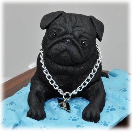 Black pug figurine on blanket, detail